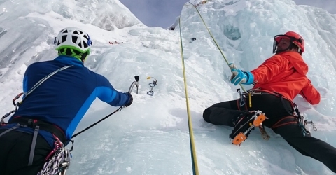 photo of two people climbing a glacier
