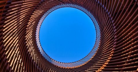 photo of a blue sky looking up through cylindrical structure