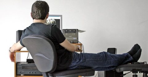 sitting at computer desk with feet up