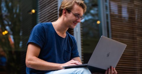 a man looking happy while using a laptop
