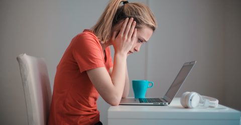 a woman looking frustrated while using a laptop